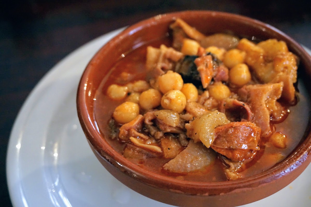 Un plato de estofado de callos con cerdo y garbanzos