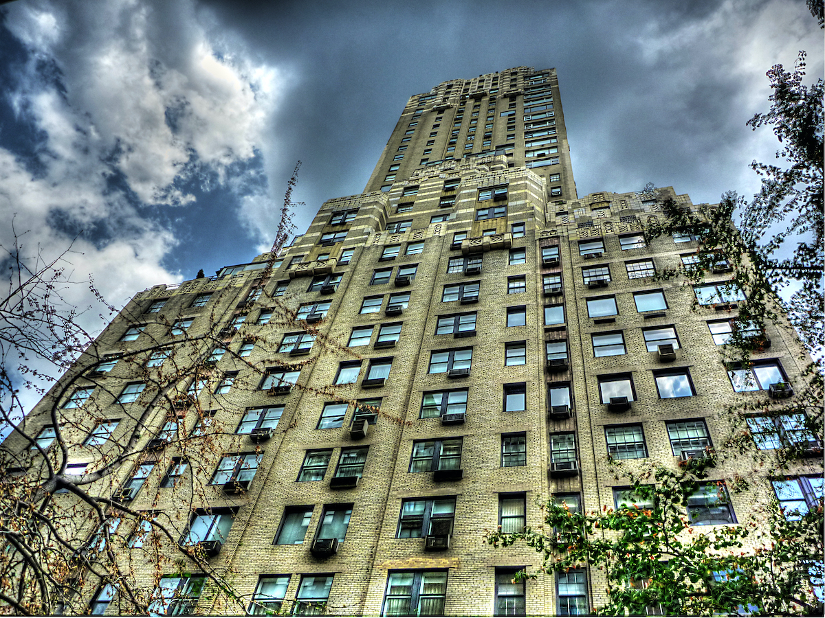 Una vista aérea de un hotel de lujo de varios pisos en Nueva York con una fachada de piedra beige.