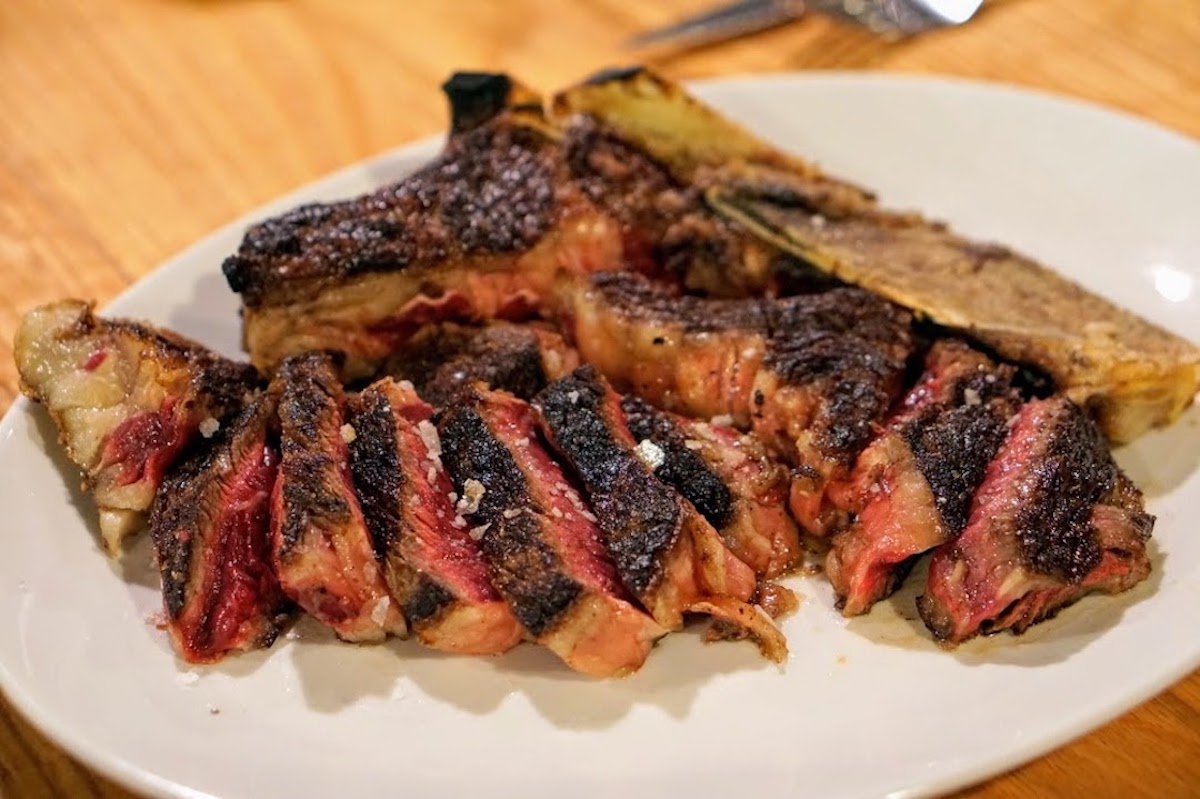 Chuletón de buey cocido medio raro en un plato blanco