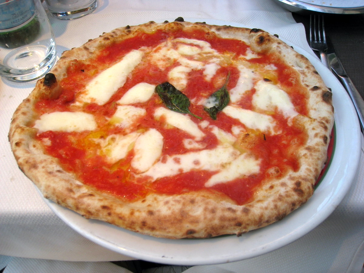 Pizza al estilo napolitano adornada con albahaca