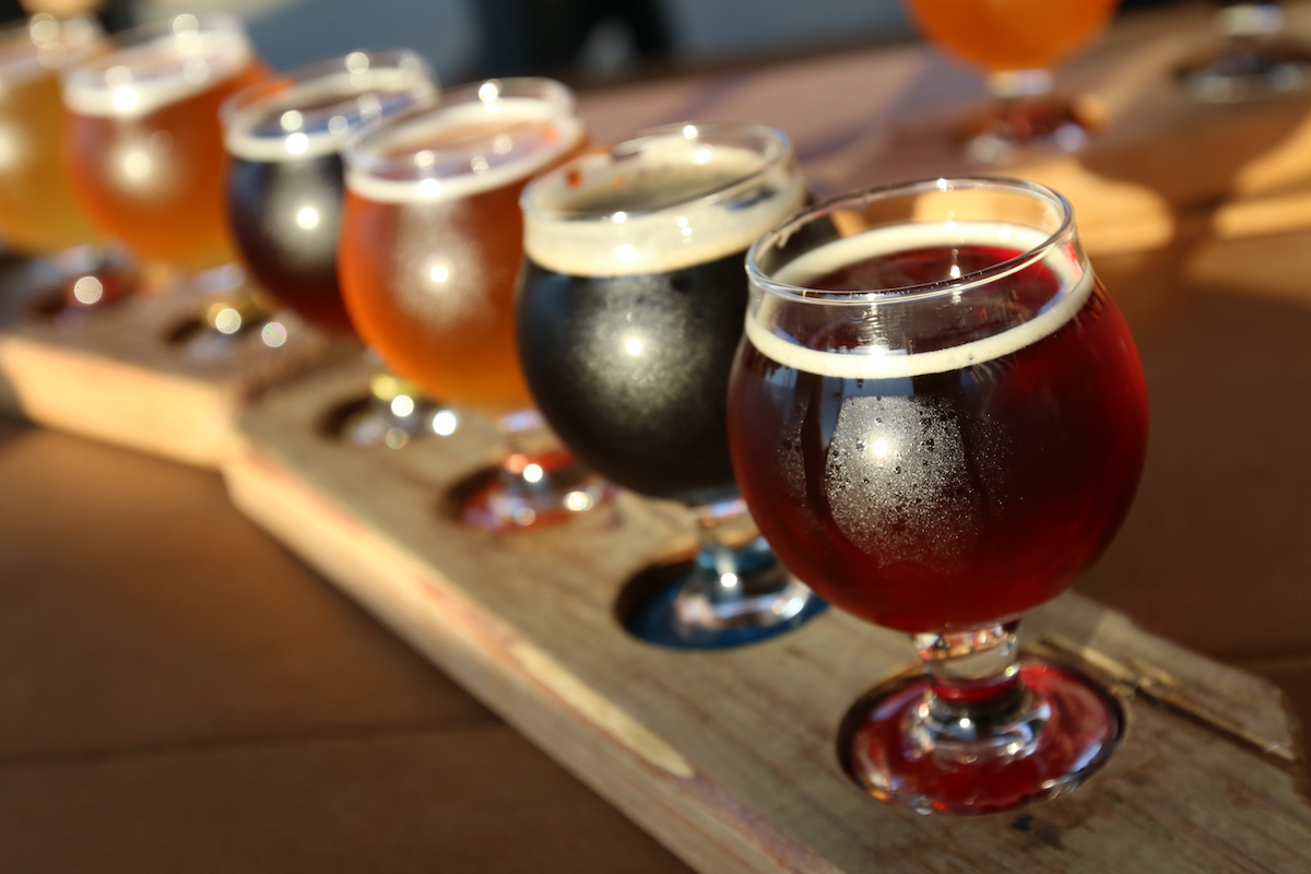 La cerveza de color oscuro vuela sobre una tabla de madera