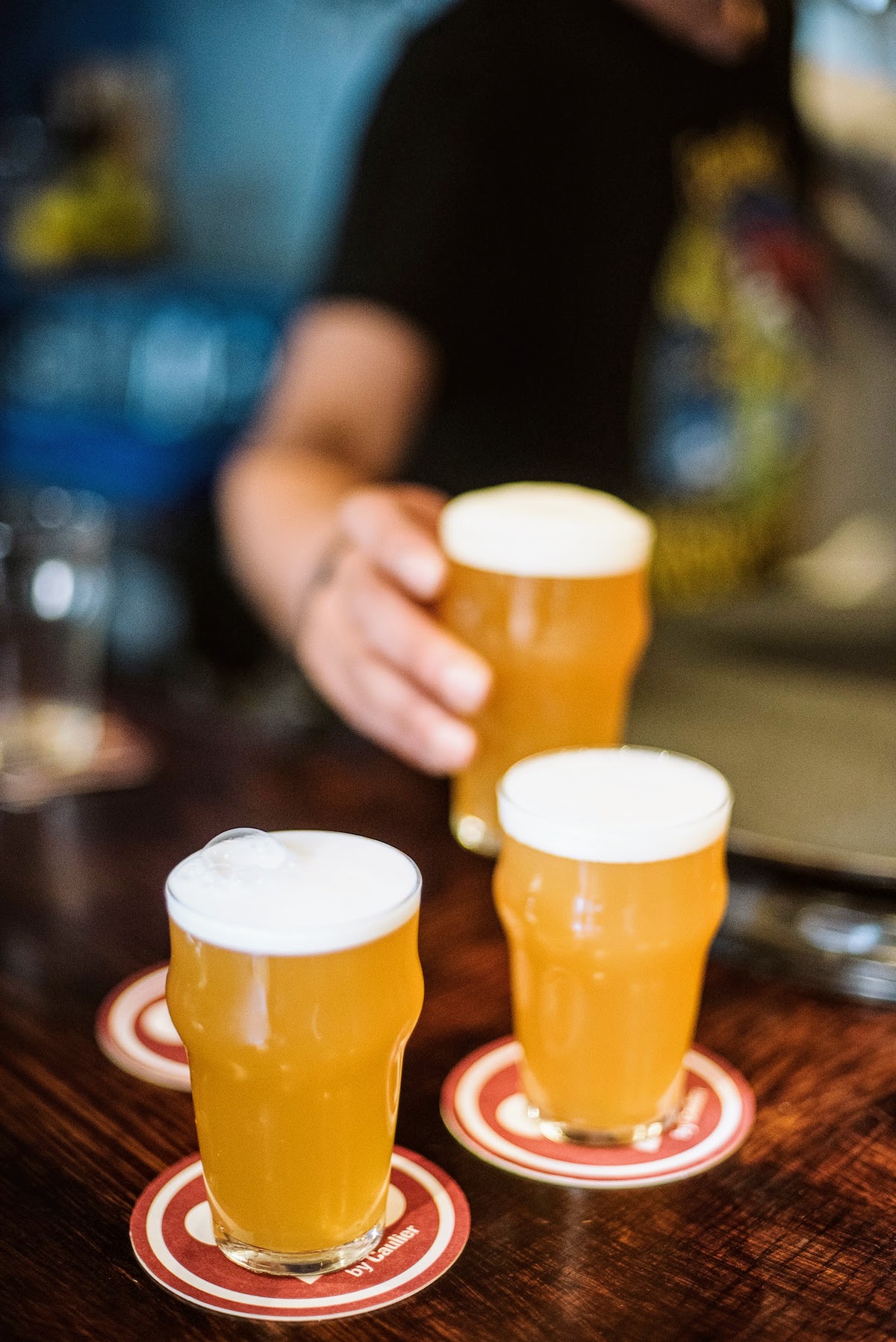 Tres pequeñas cervezas artesanales en posavasos circulares