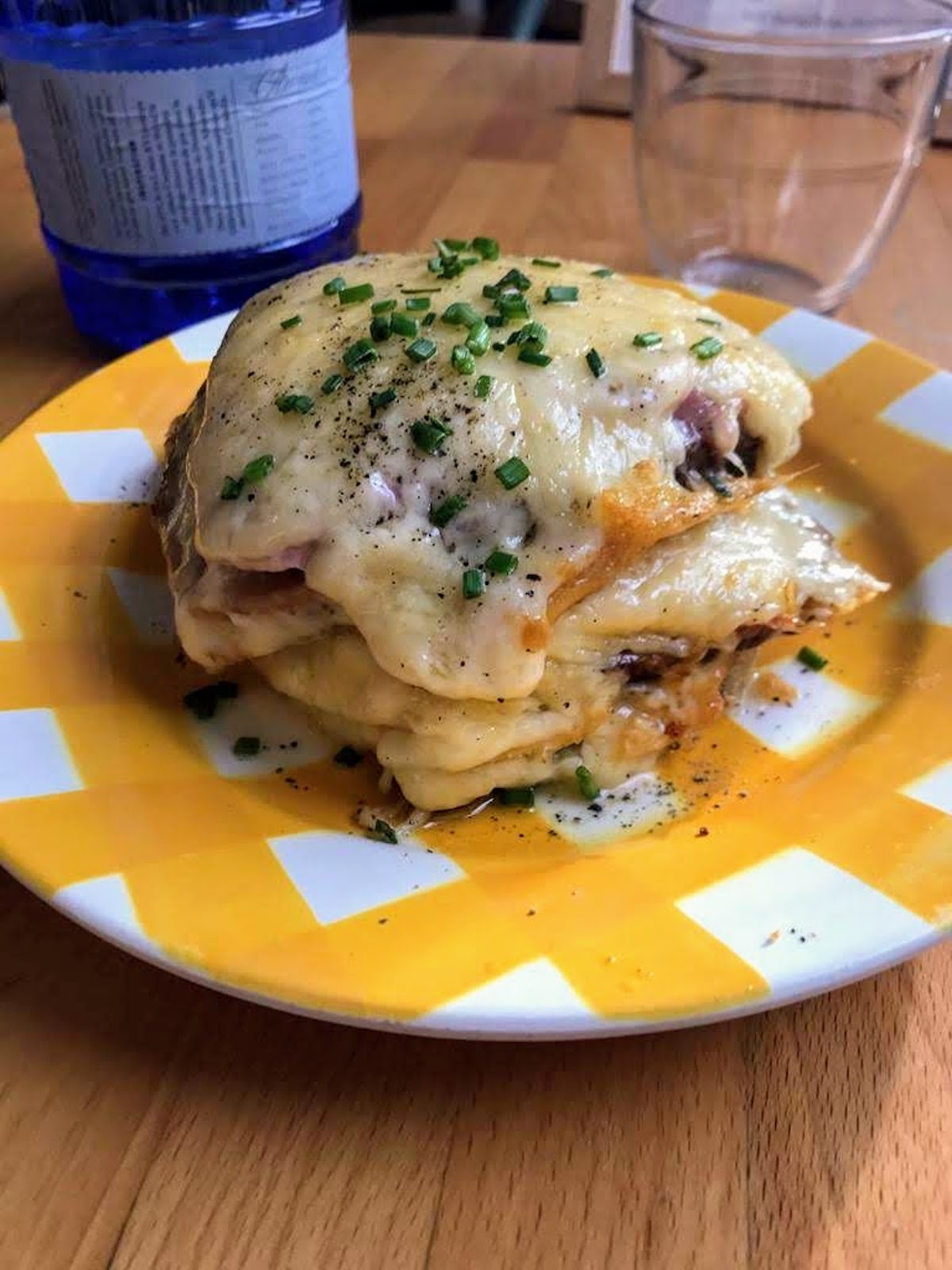 Sándwich de croque monsieur en un plato amarillo y blanco