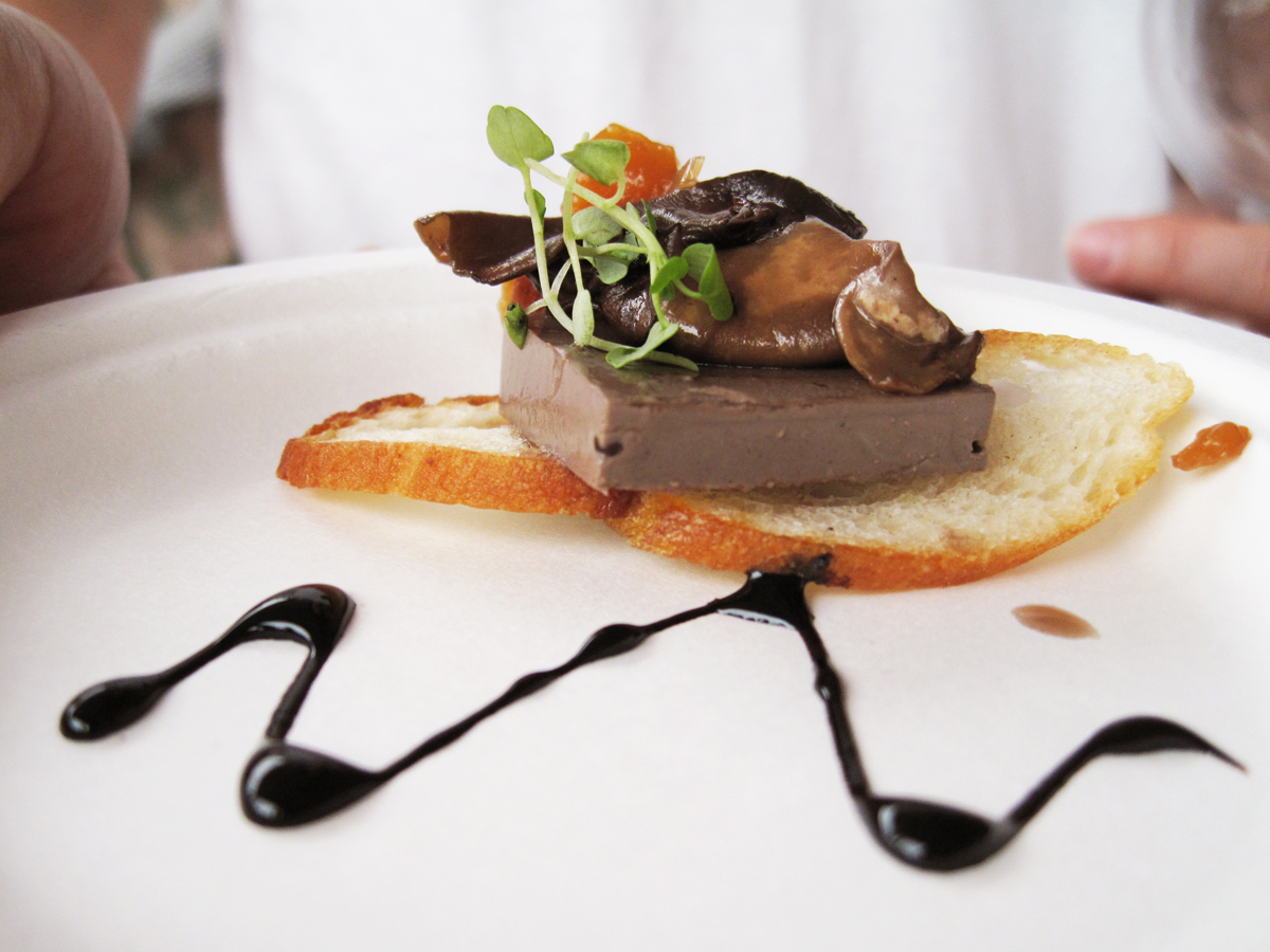 en rodajas finas y cubierto con mousse de champiñones portobello y compota de durazno e hinojo.