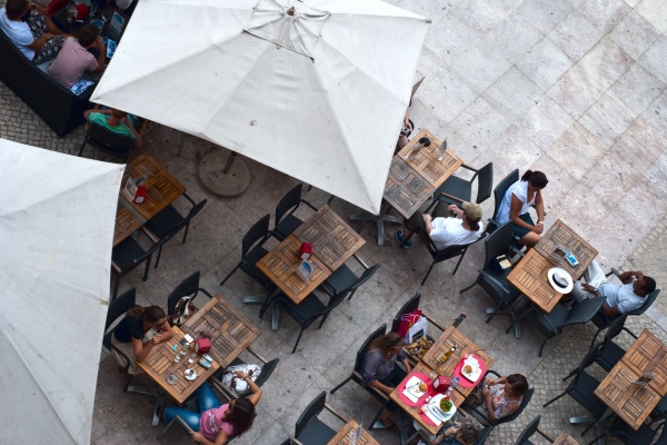 Personas sentadas para almorzar afuera en un café en Lisboa. ¡Come como un local en Lisboa!