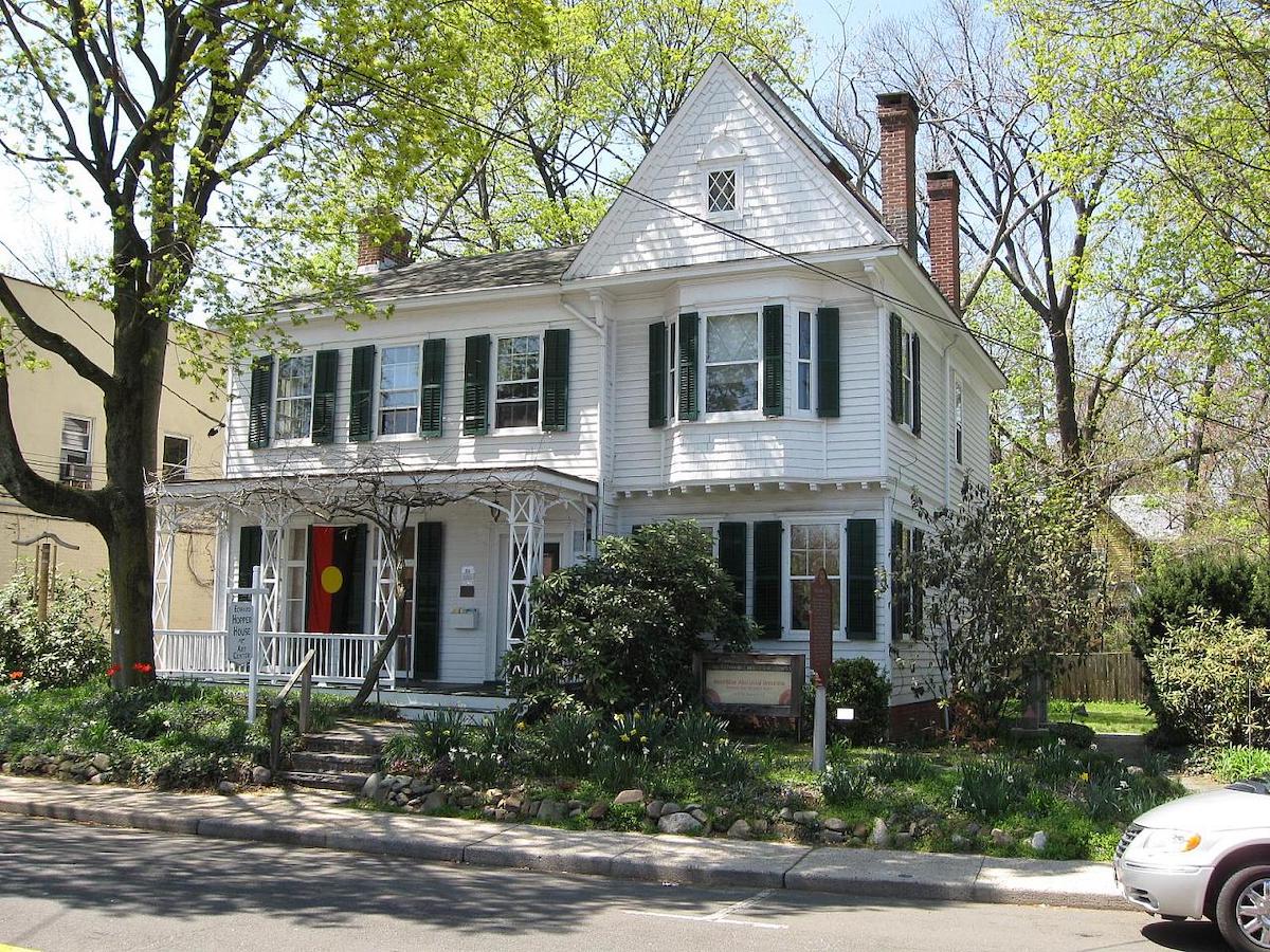 Una casa blanca de dos pisos en una calle suburbana
