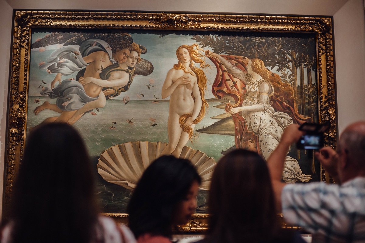 Una mujer al amanecer en un museo con visitantes tomándole fotos