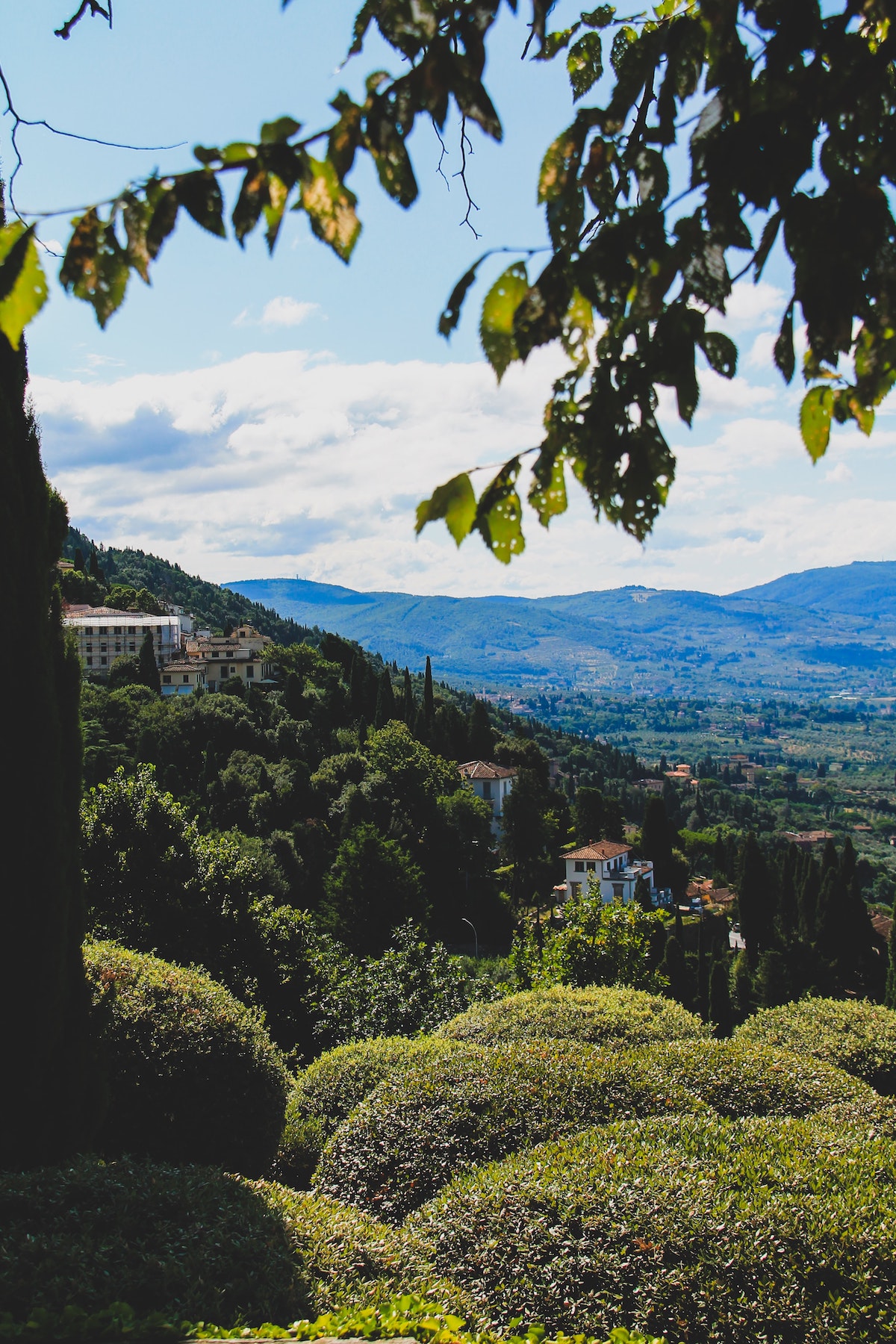 Una zona montañosa verde con algunos edificios pequeños en la distancia