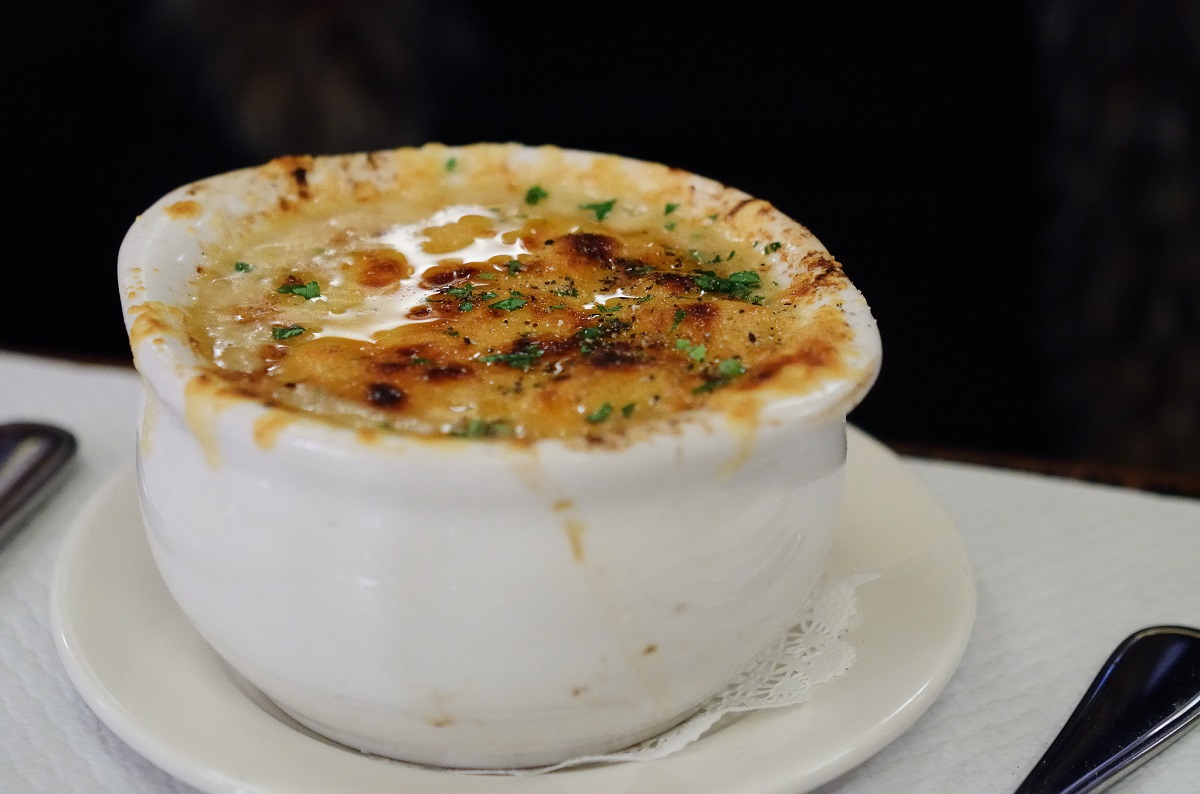 Cerrar la sopa de cebolla francesa en un cuenco de porcelana blanca