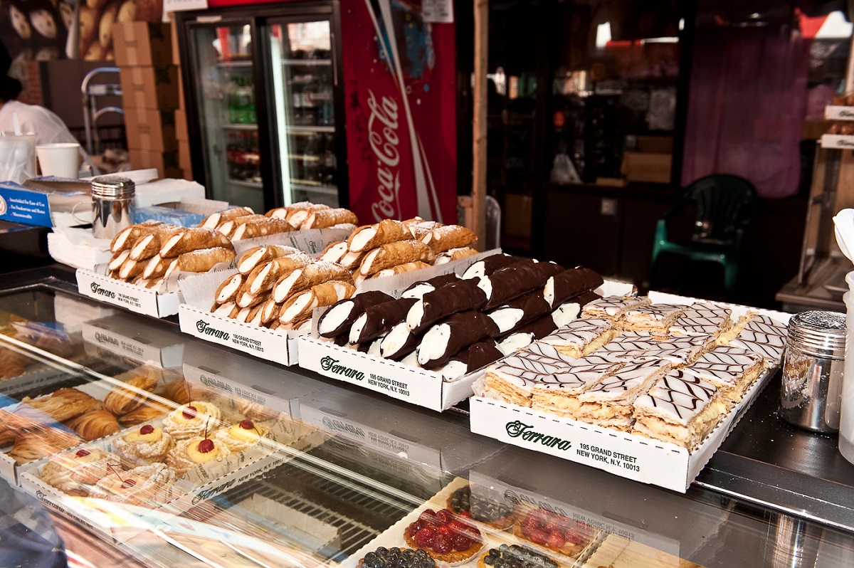 Bandejas de cannoli de chocolate y pasteles rellenos de crema en un mostrador al aire libre