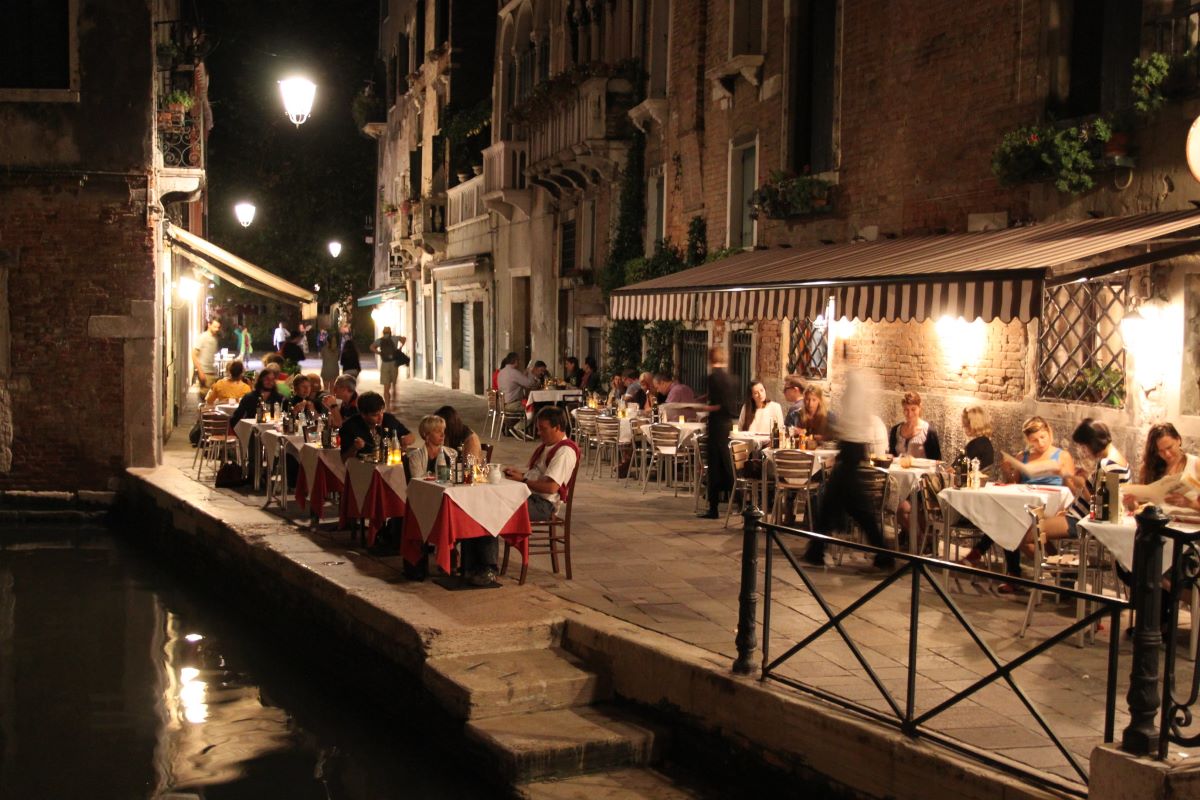 gente sentada en el restaurante por la noche en el canal
