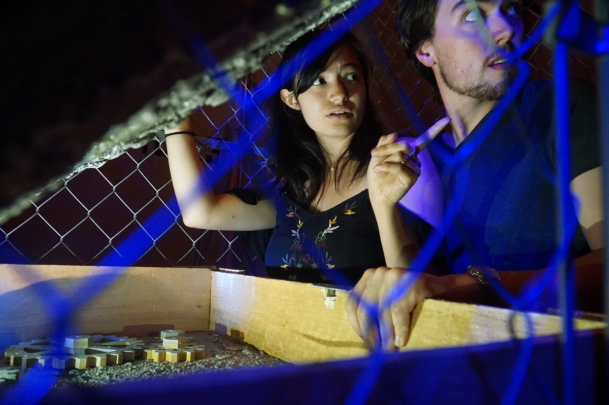Una pareja en la oscuridad levanta la tapa de una caja iluminada