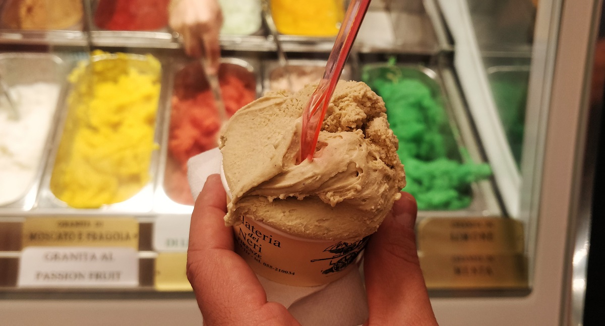 Una pequeña taza de helado frente a sorbetes multicolores