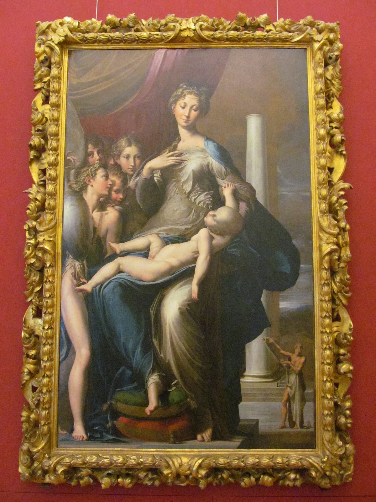 Una pintura al óleo en un marco dorado de una mujer con un cuello largo y un niño extrañamente grande