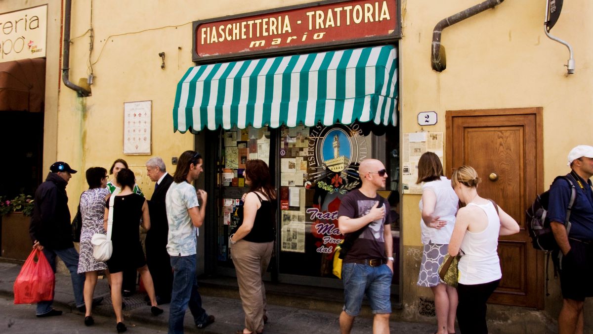 personas de pie frente a la entrada