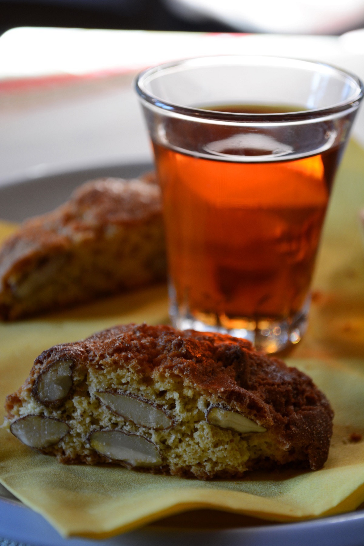 Un vaso de líquido de color ámbar con galletas de almendras duras