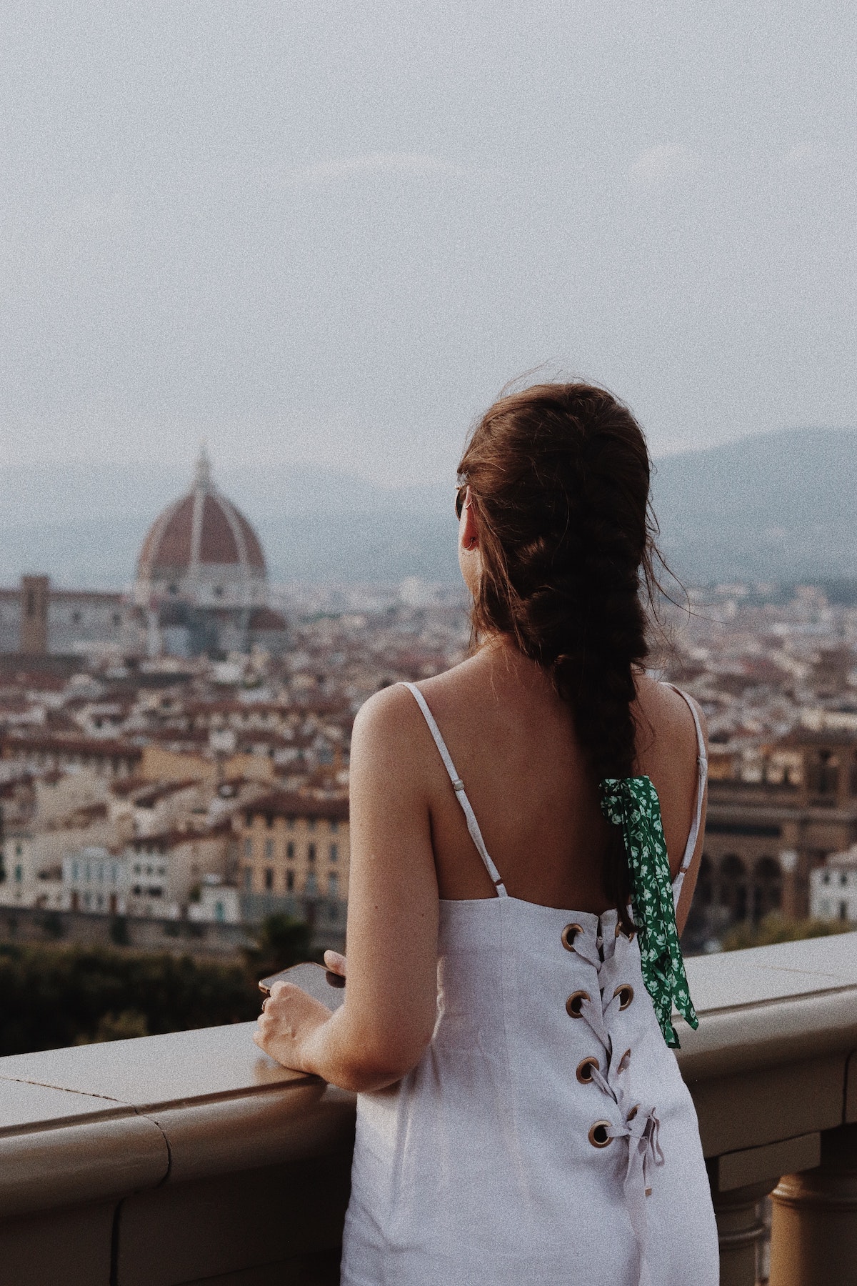 Una mujer con un vestido blanco mirando la ciudad de Florencia.