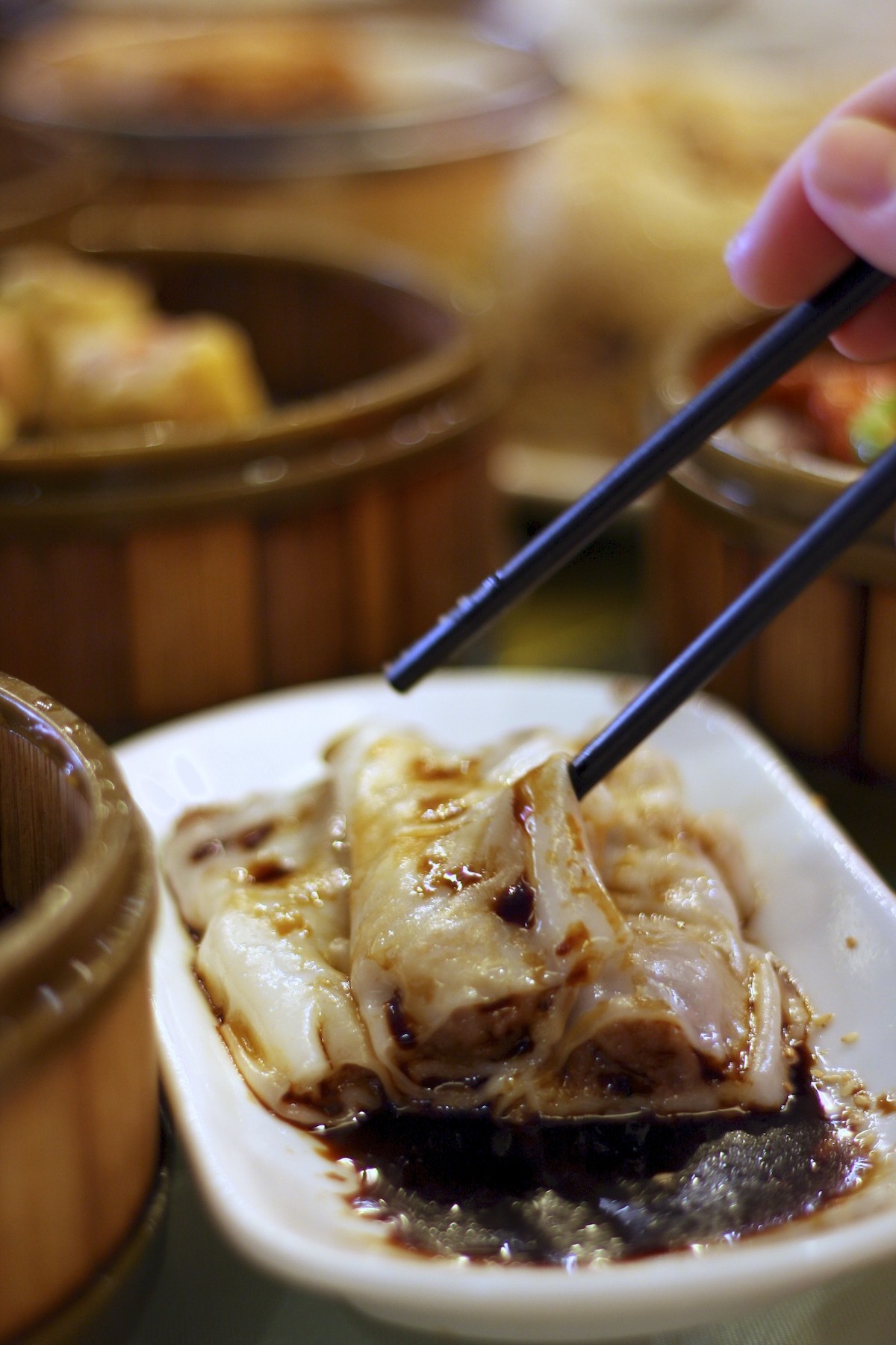 Un par de palillos sobre un plato de bola de masa china en salsa de soja