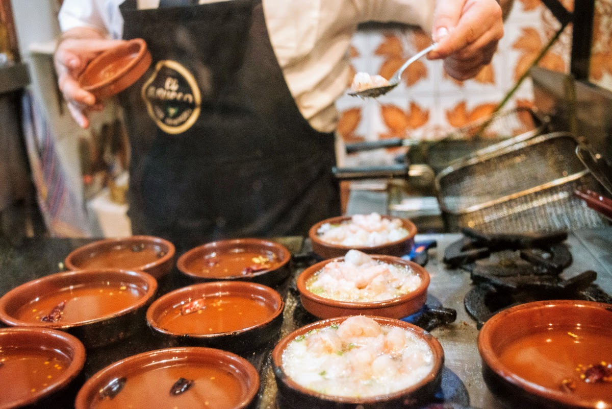 Cocinar camarones en platos individuales de terracota a la parrilla