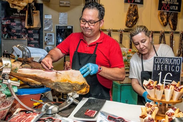 Un puesto de jamón en el mercado de Sevilla