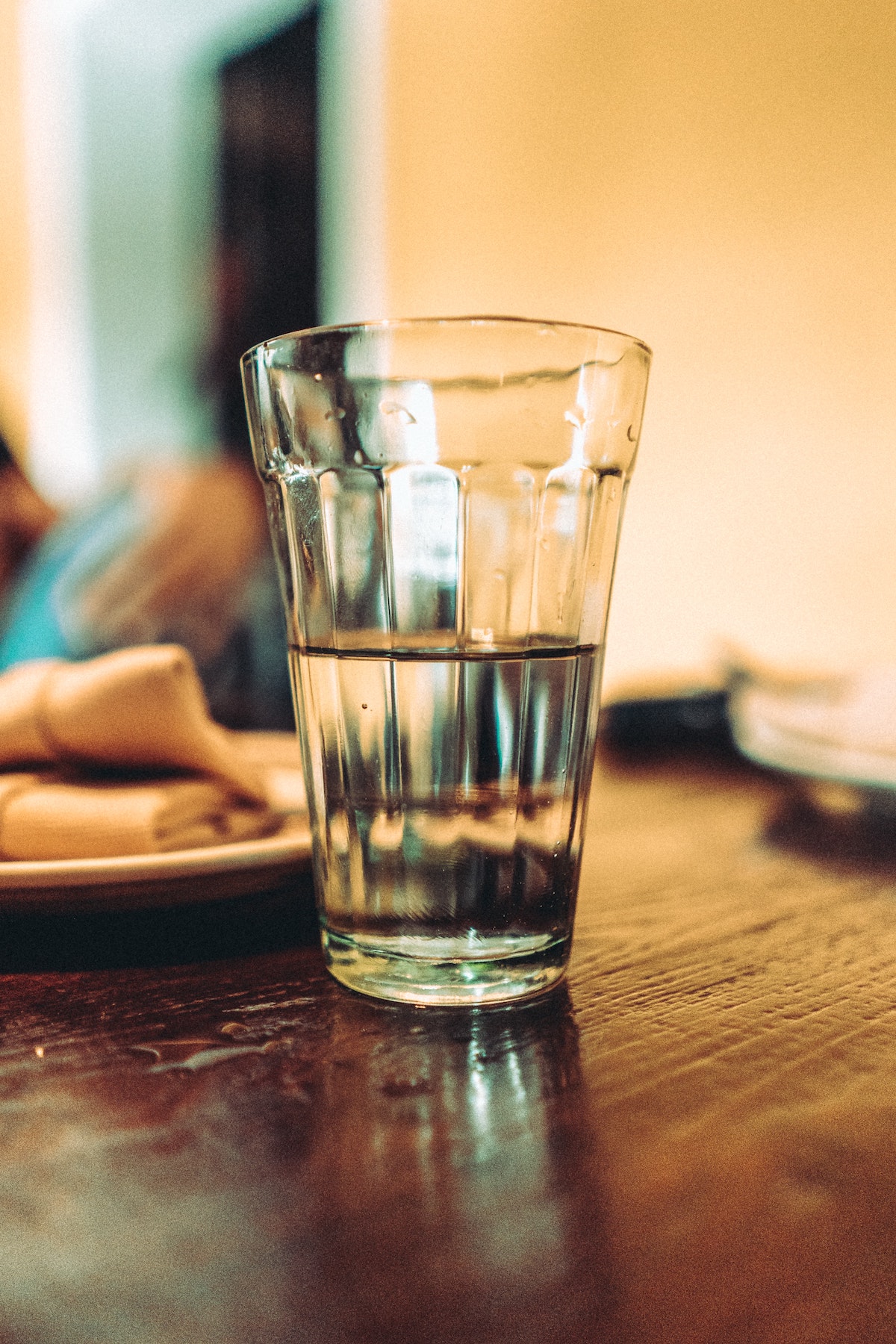 Vaso de agua clara sobre una mesa de madera