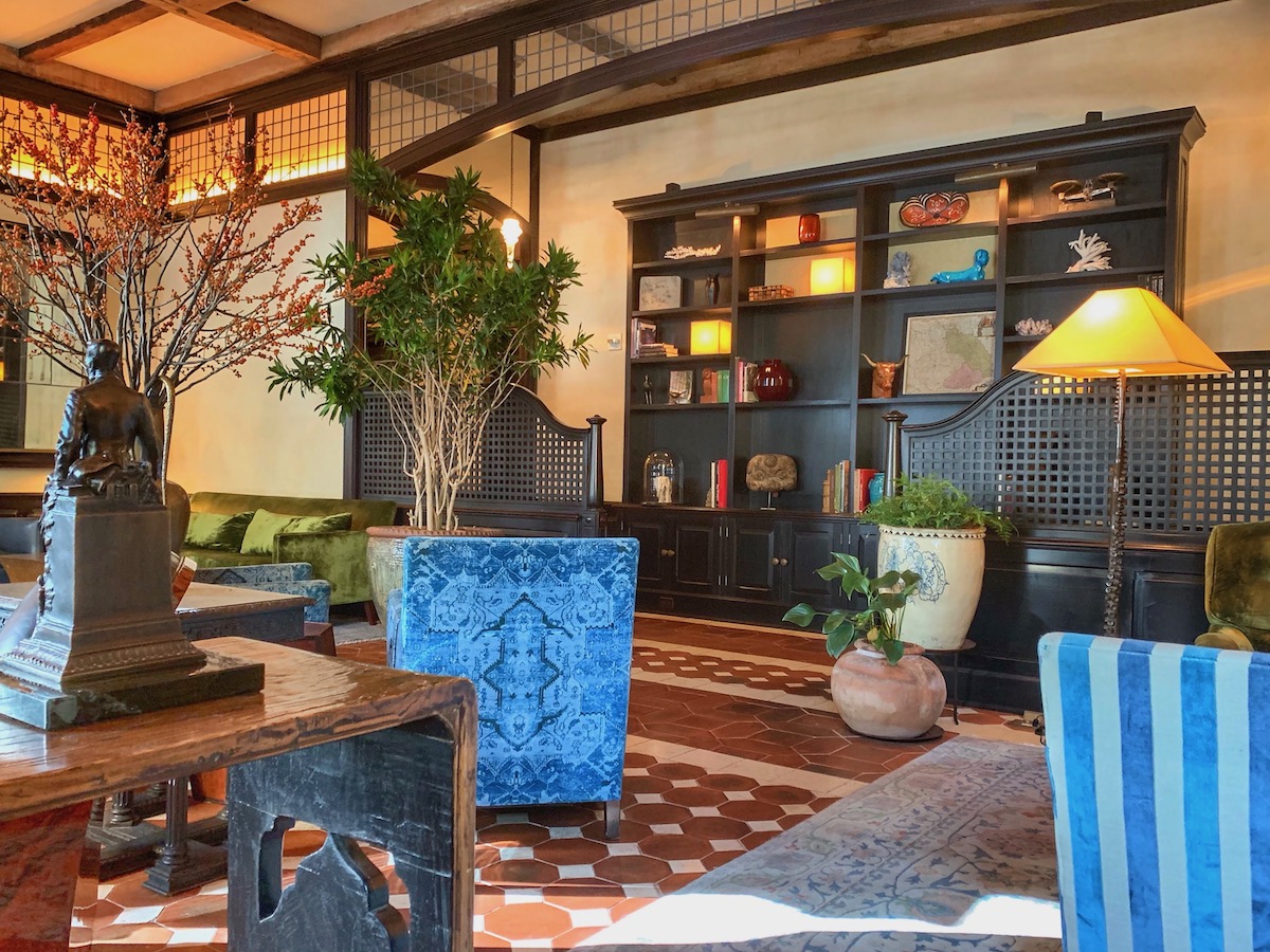 Interior del vestíbulo de un hotel con toques de madera blanda y detalles en azul
