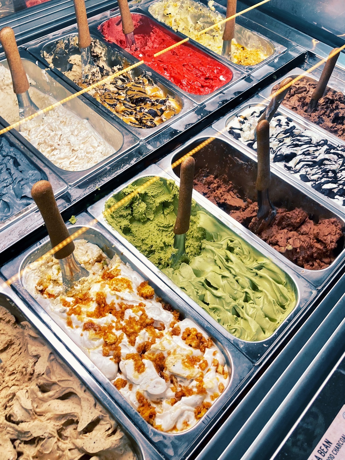 Contenedores de metal con helado en muchos colores diferentes