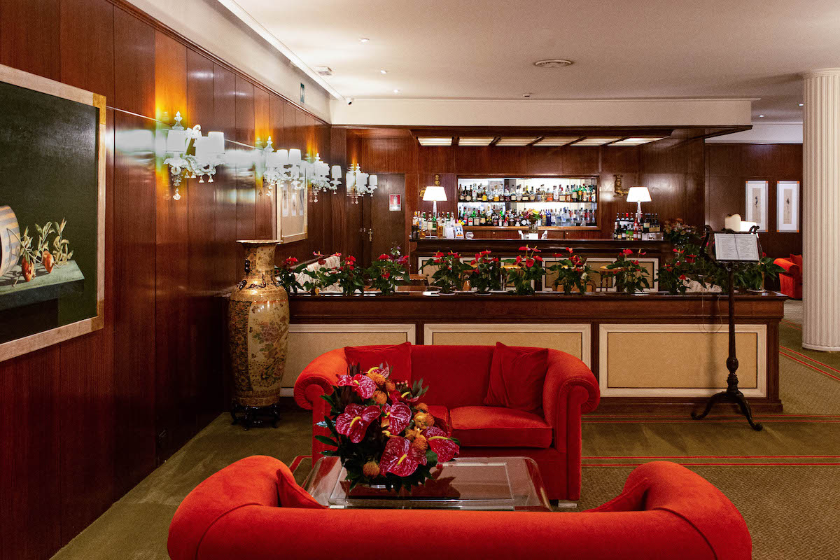 El bar de un hotel con sillones rojos y paredes con paneles de madera