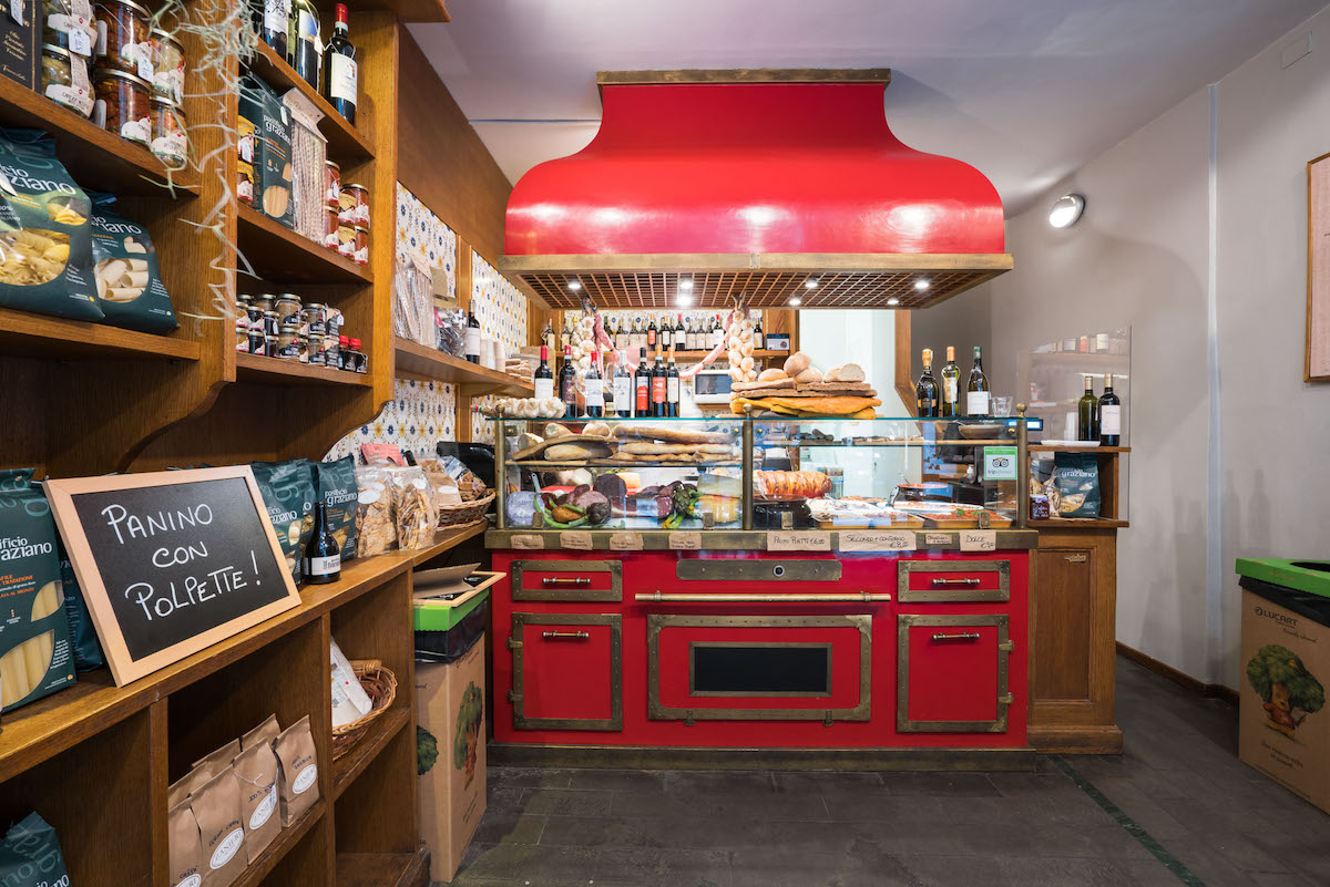 Interior de un restaurante estilo panadería con detalles rojos alrededor del mostrador