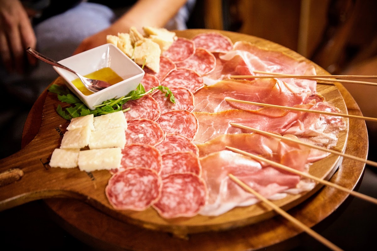 Tabla de quesos y charcutería estilo italiano servida en el aperitivo