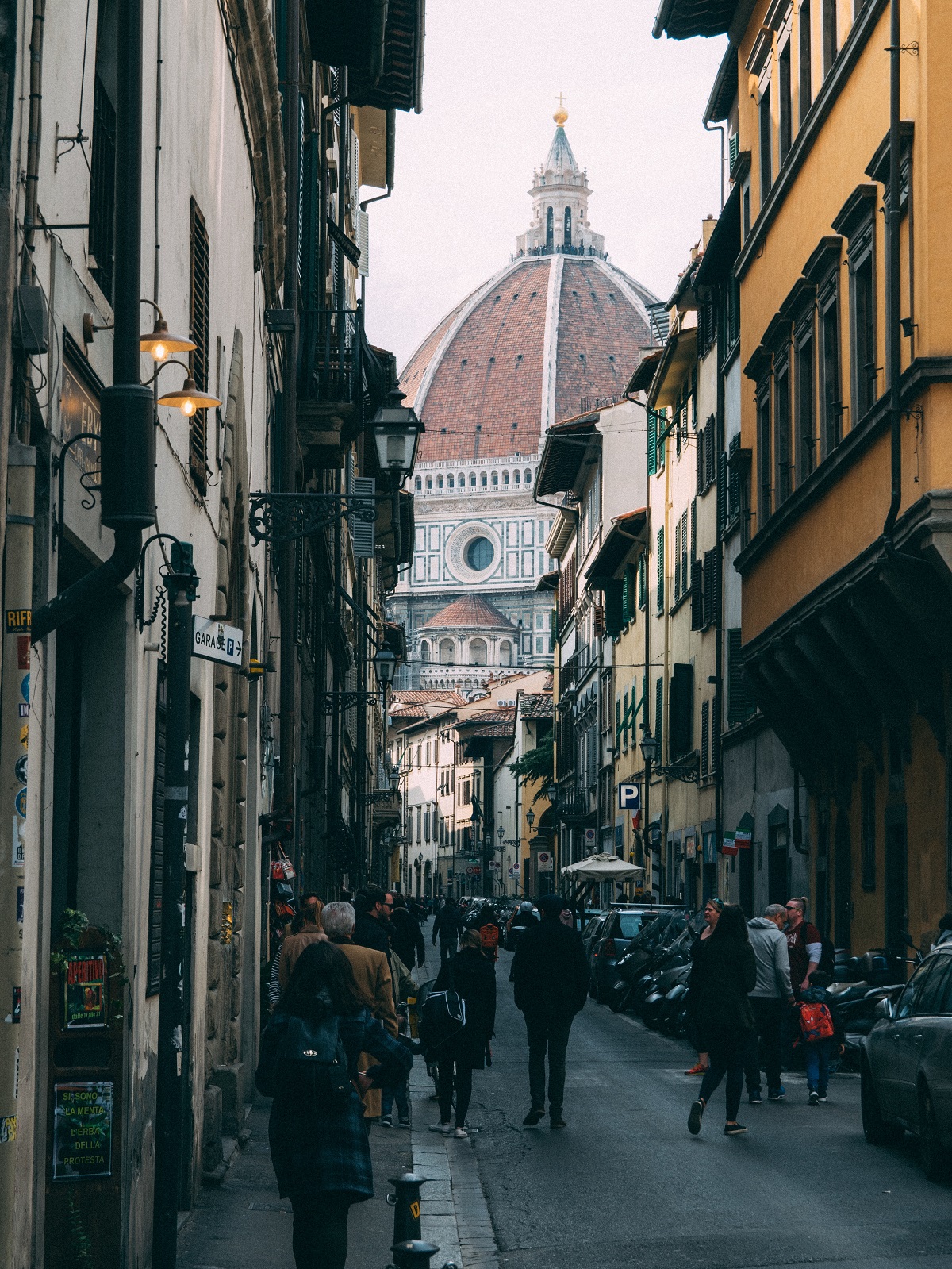 Una calle concurrida en Florencia con el duomo al fondo