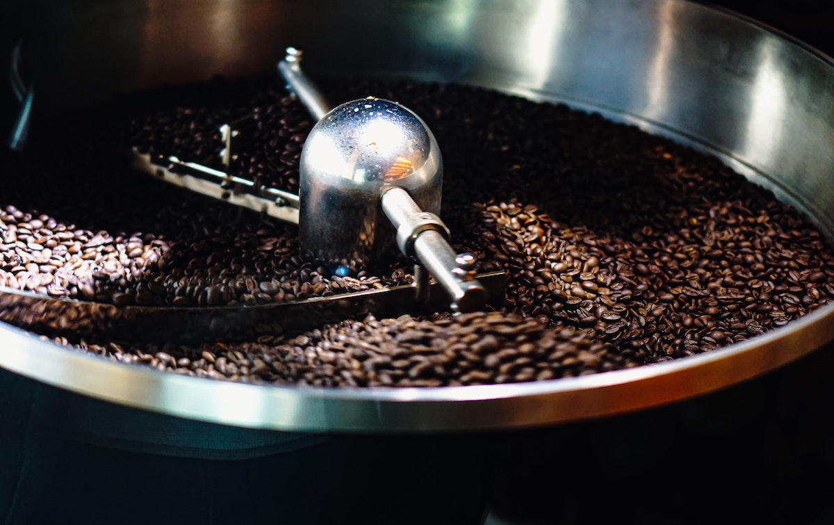 Cerca de granos de café en una tostadora