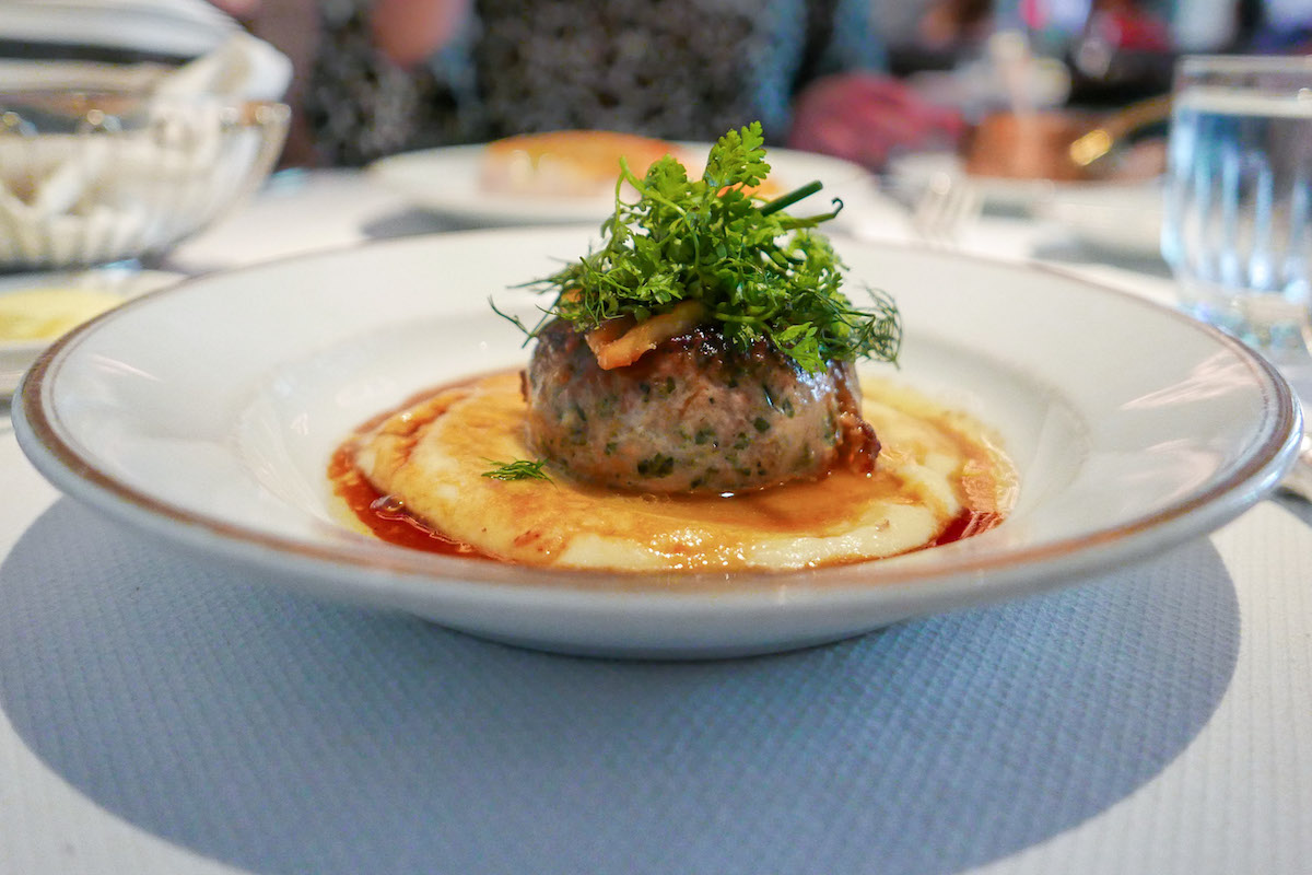 Una presentación moderna de salchicha de ave con foie gras y fruta en un restaurante francés