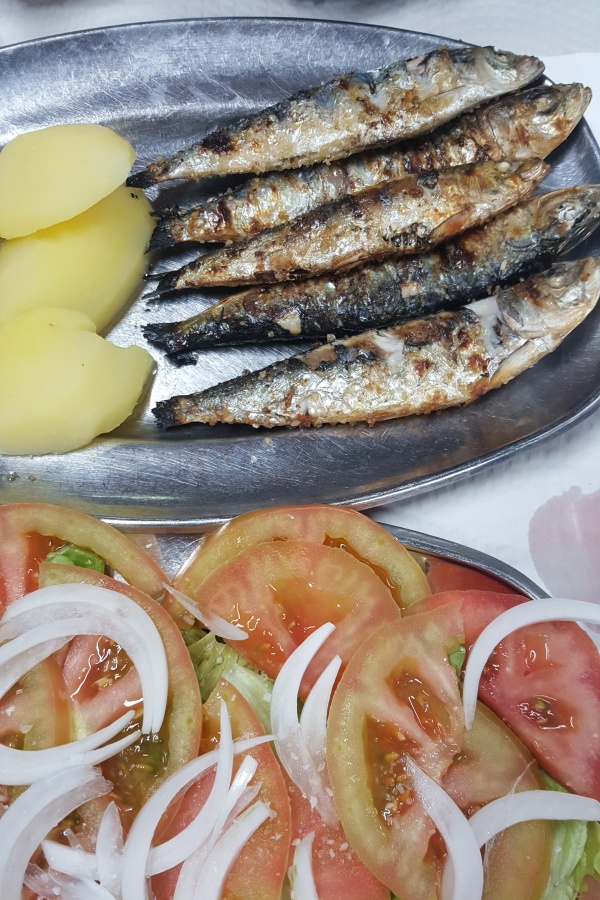 Fuentes de acero inoxidable con sardinas a la plancha y ensalada de tomate