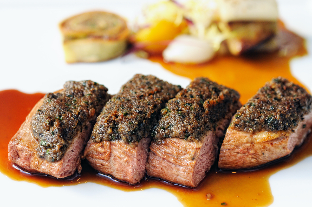 Rebanadas de pechuga de pato a la parrilla en un plato con salsa marrón
