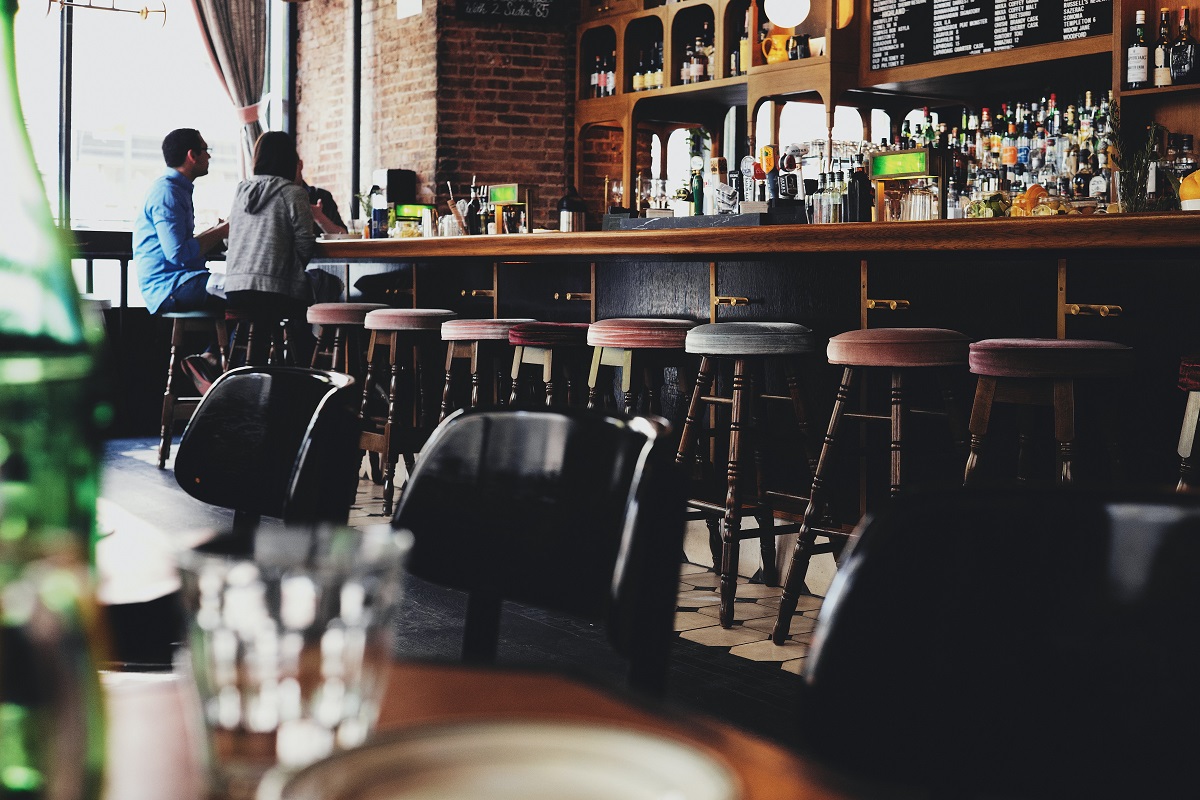 Dos personas se sientan en un bar detrás de un restaurante.