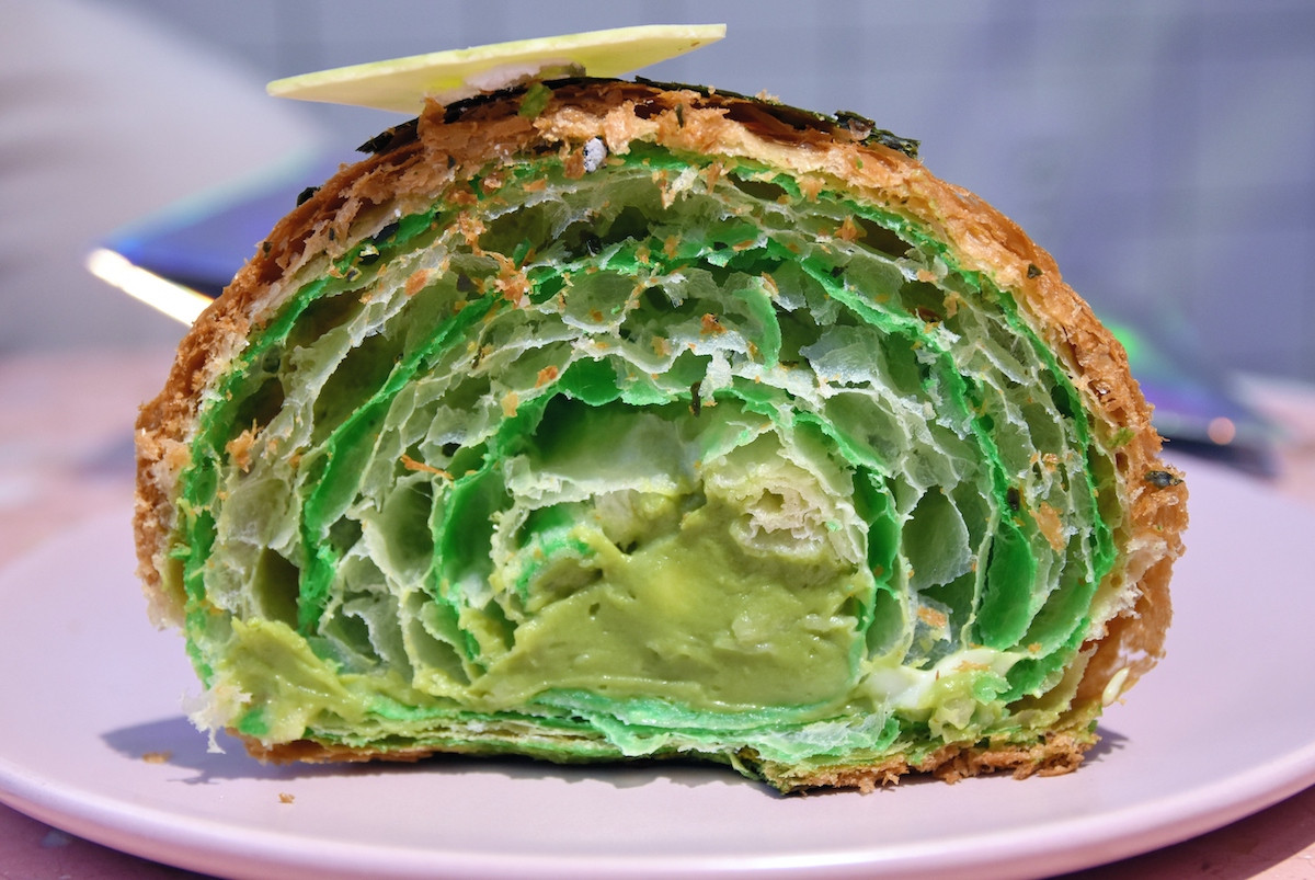 Una sección transversal de un croissant relleno de crema verde