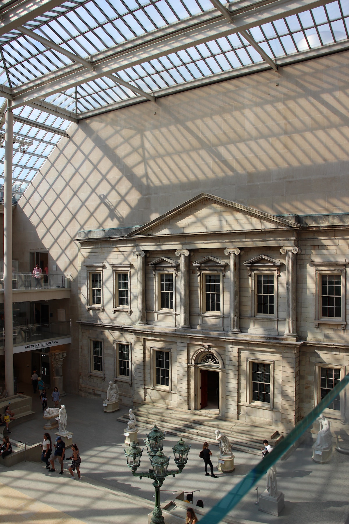 Interior del museo con techos altos, ventanas y luz que entra por las rejas