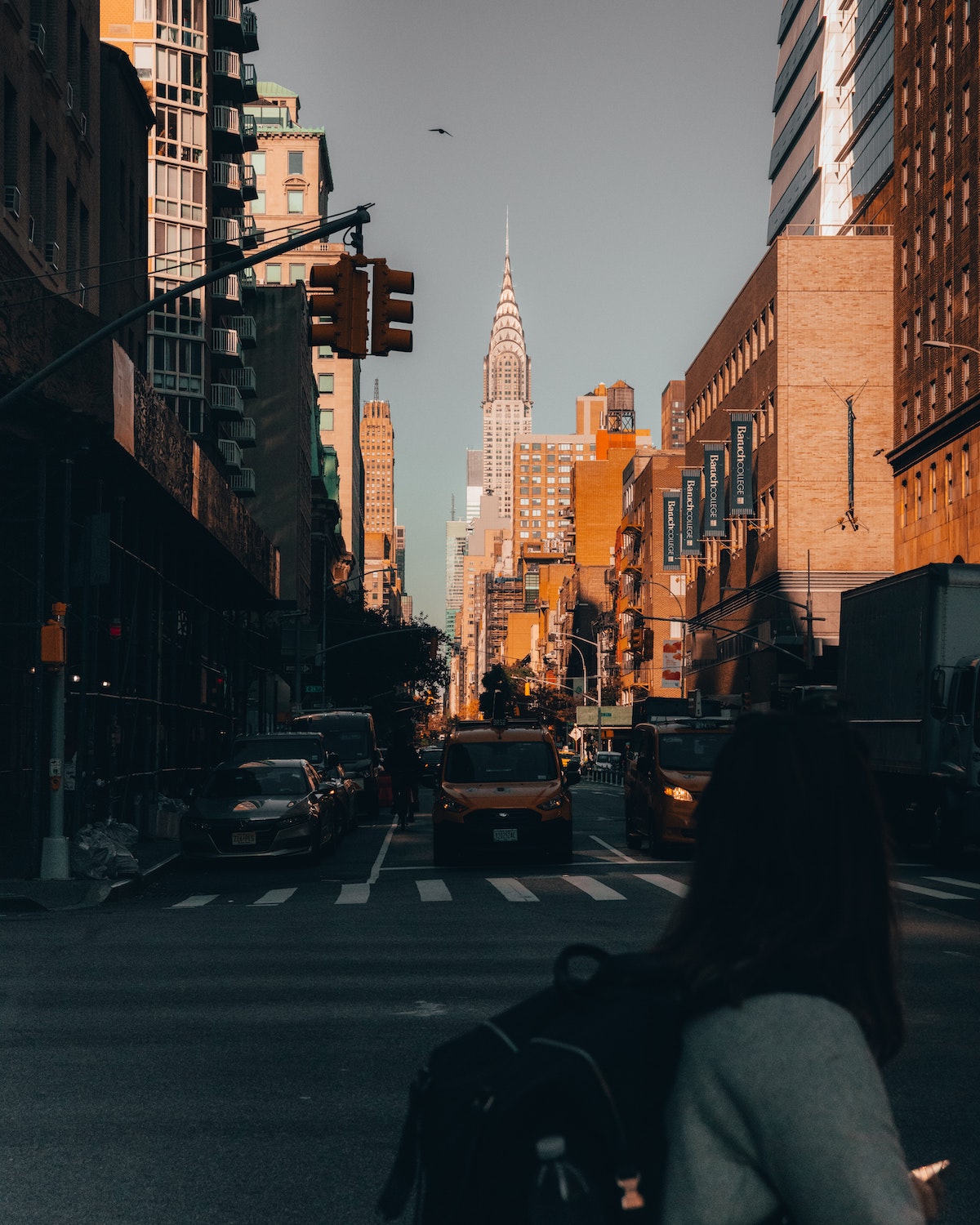 Una concurrida calle de la ciudad en Midtown Manhattan con un alto rascacielos en el fondo