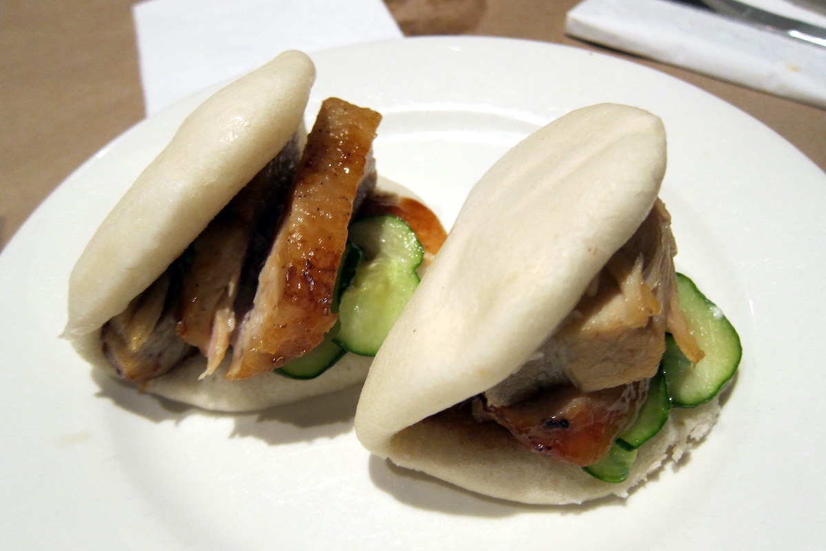 Dos bollos bAO rellenos de cerdo crujiente y pepino