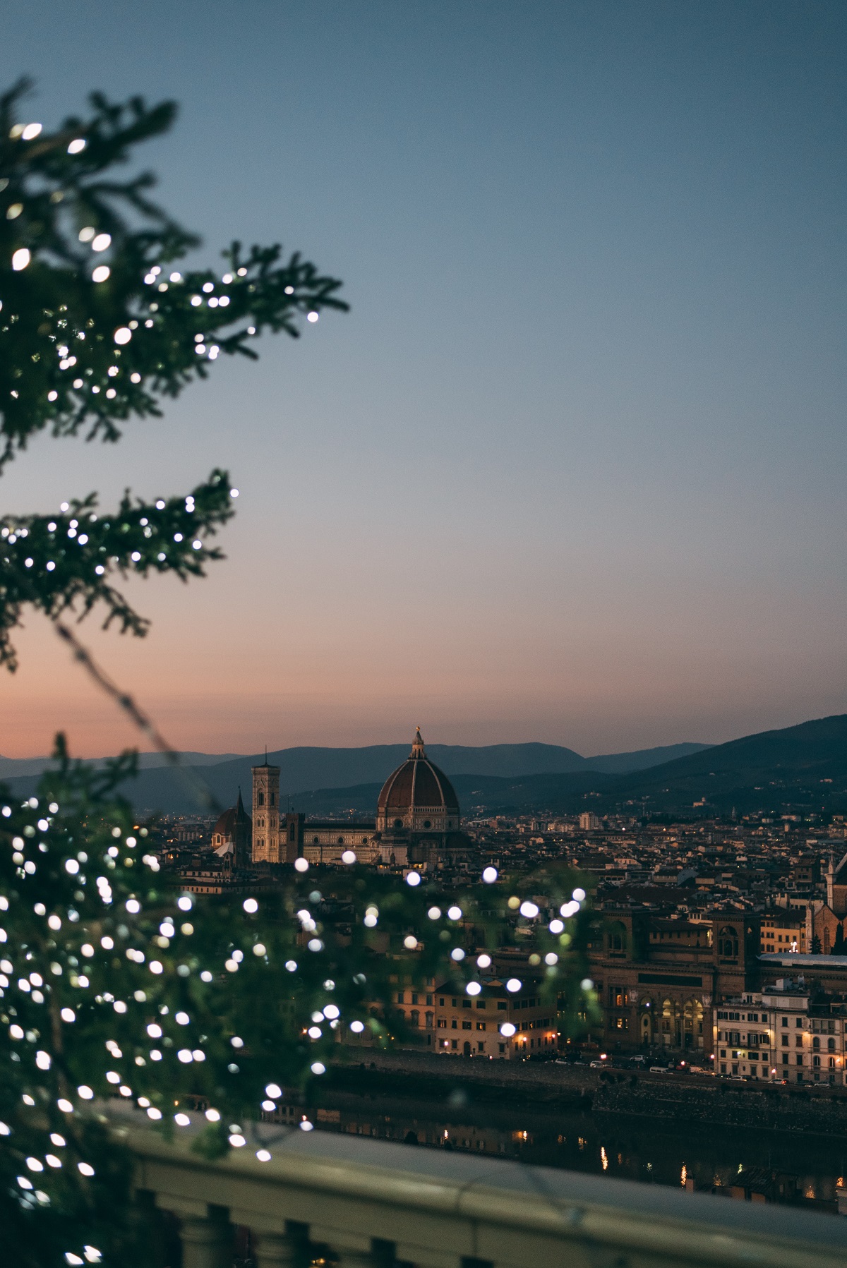 Florencia en invierno con luces navideñas, vista desde la cima de una colina