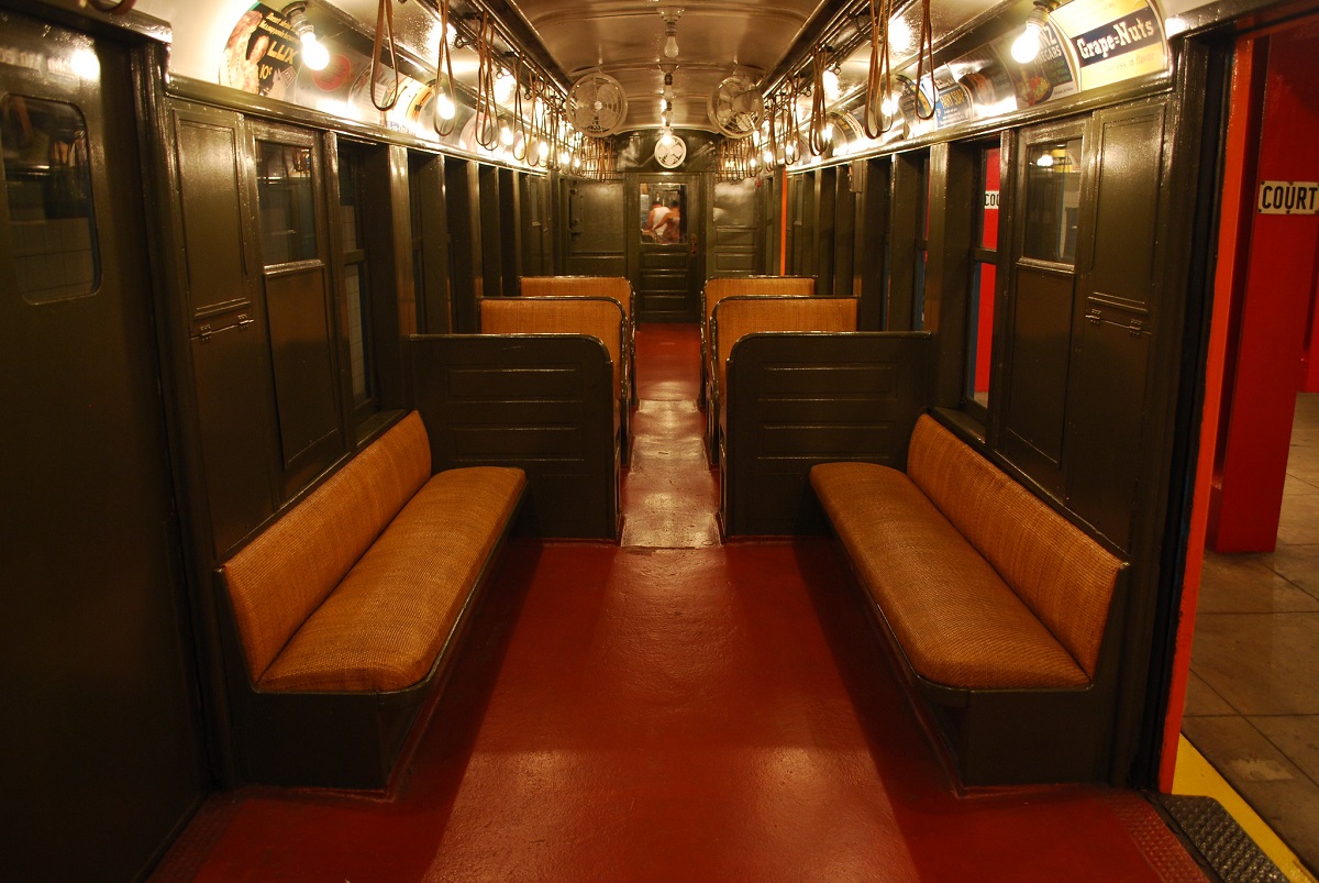 Interior oscuro de un viejo vagón de metro, débilmente iluminado con bombillas de flash