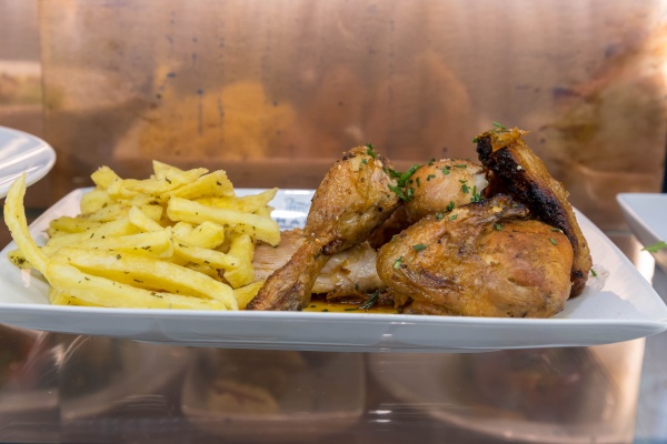Trozos de pollo a la parrilla con papas fritas en un plato blanco. Saber lo que está recibiendo es parte del proceso de pedido en Portugal. 