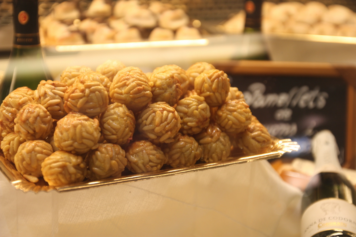 Paneles (pequeños dulces en forma de bola cubiertos de piñones) sobre una fina bandeja dorada