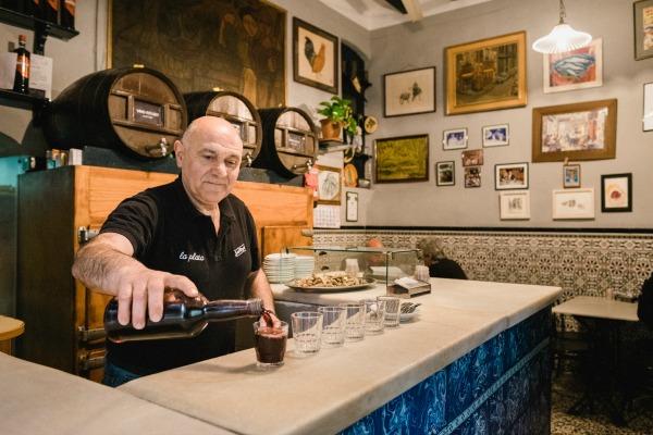 Pepe (propietario del Bar La Plata de Barcelona) sirviendo vino tinto en la casa