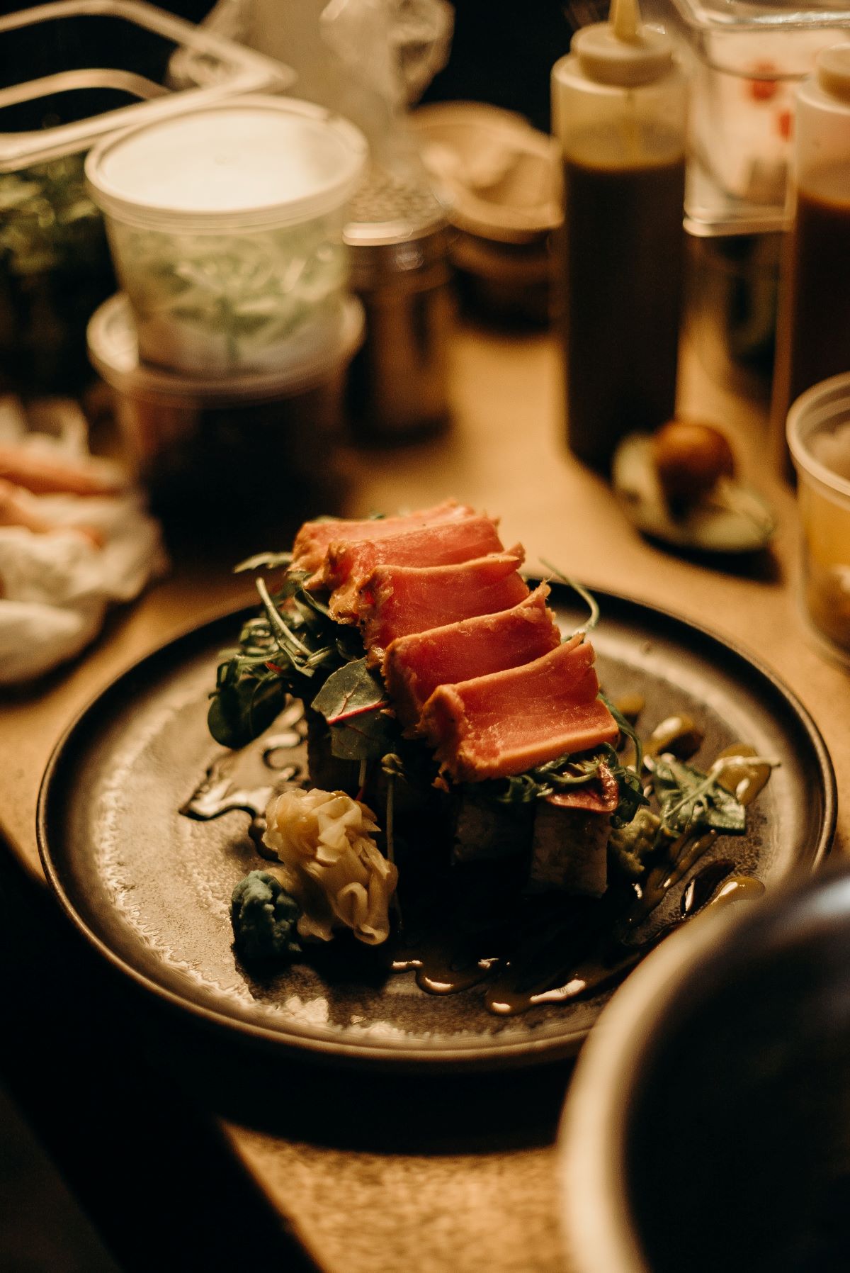 tataki sobre verduras y un plato negro