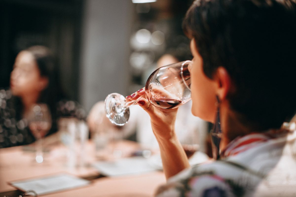 mujer tomando un sorbo de vino tinto