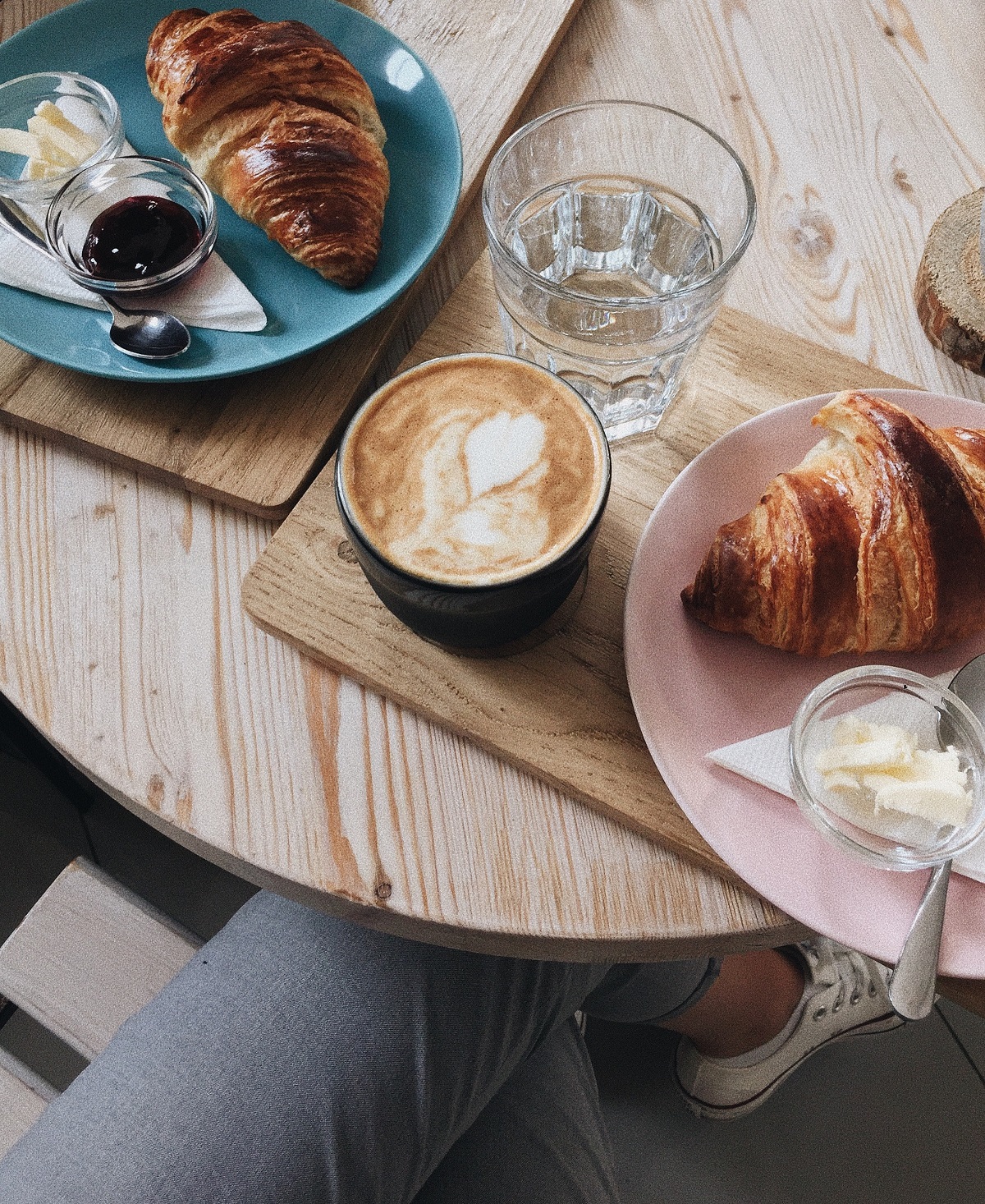 Bandejas de desayuno con café y croissants en una mesa interior