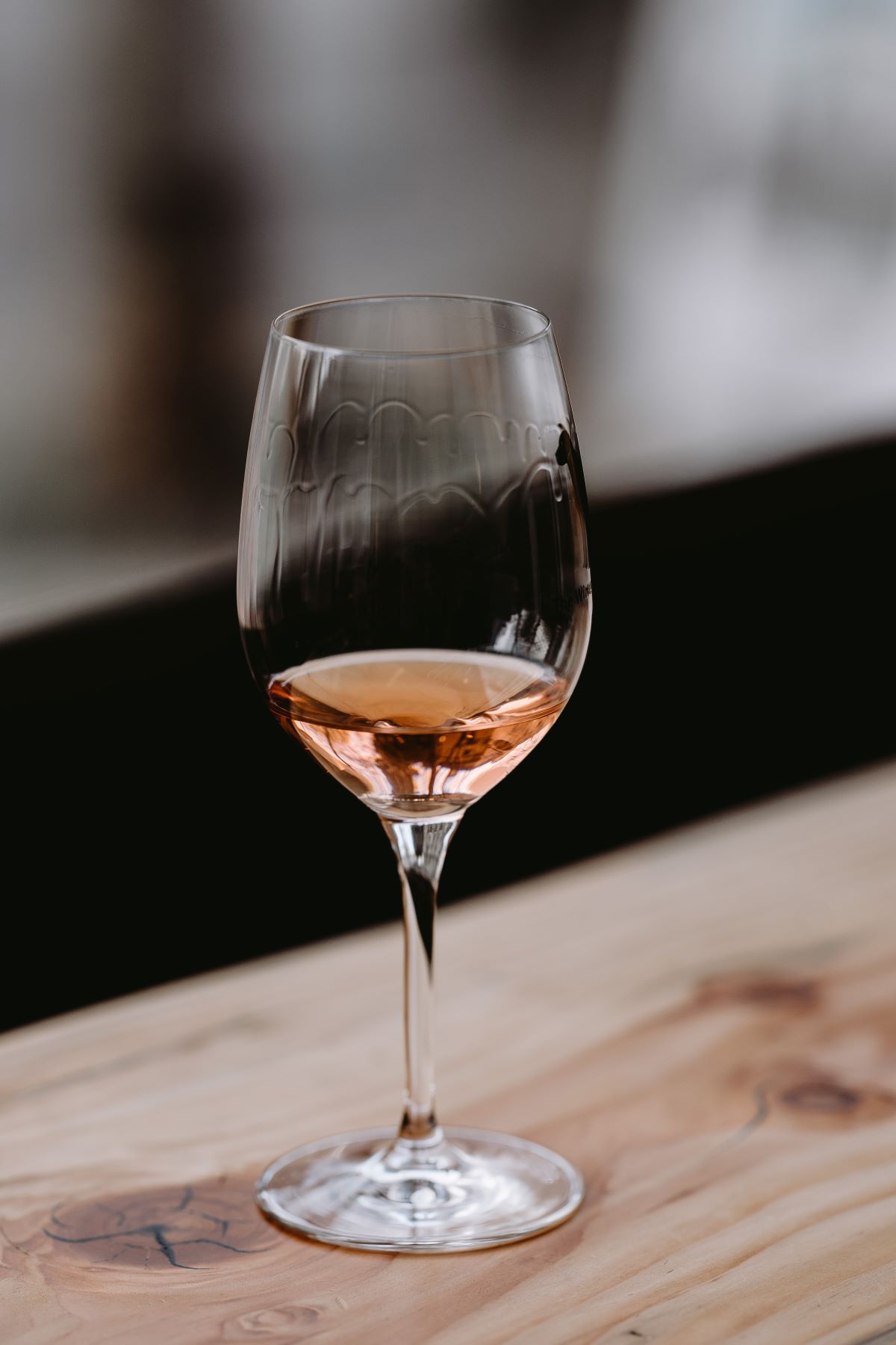 copa de vino rosado en el estante de madera