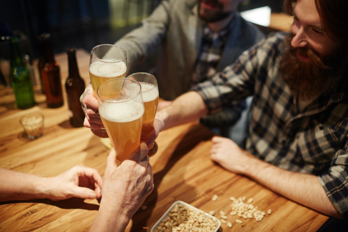 hombres brindando en un bar con cerveza: la mejor hora feliz de Nueva York